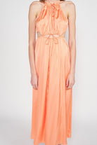 Close-up of gathered halter neck and waist tie detail on peach satin midi dress