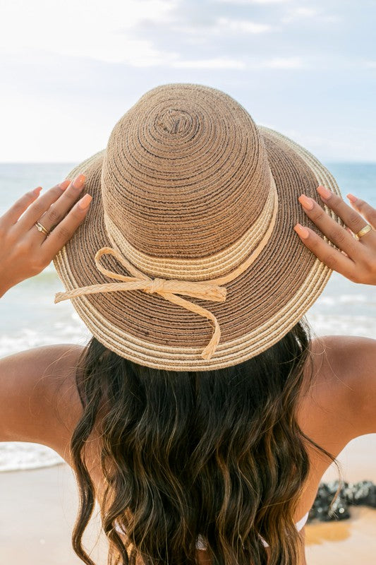 Straw bucket sun hat with raffia tie detail back view on beach