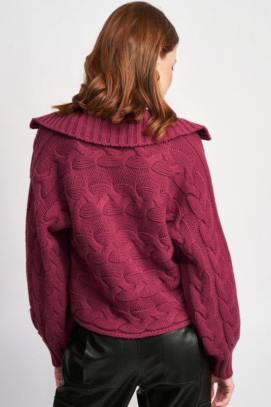 Back of burgundy cable-knit sweater showing full cable pattern and foldover collar.
