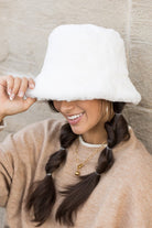 Side view of cream faux-fur bucket hat
