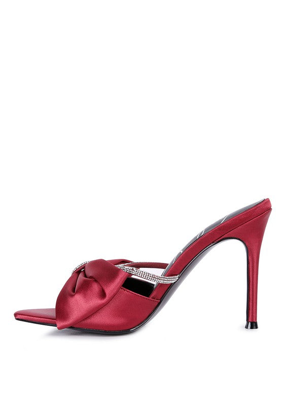 Side view of burgundy satin bow stiletto mule with rhinestone strap