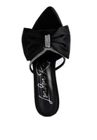 Top view of black satin heel showing oversized bow and rhinestone center