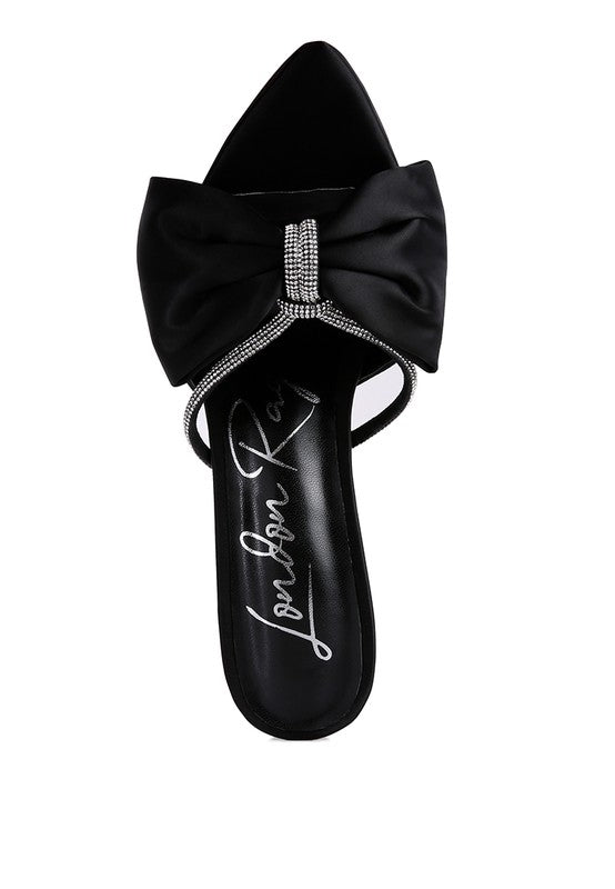 Top view of black satin heel showing oversized bow and rhinestone center