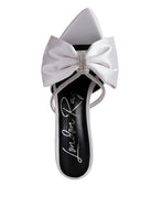 Top view of white satin heel showing oversized bow and rhinestone center

