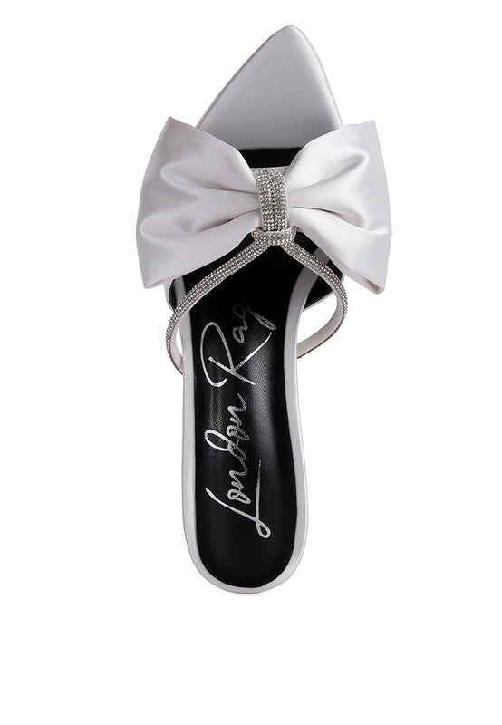 Top view of white satin heel showing oversized bow and rhinestone center

