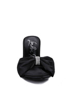 Front view of black satin heel showing oversized bow and rhinestone center