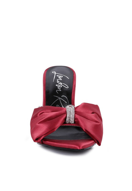 Front view of burgundy red satin heel showing oversized bow and rhinestone center