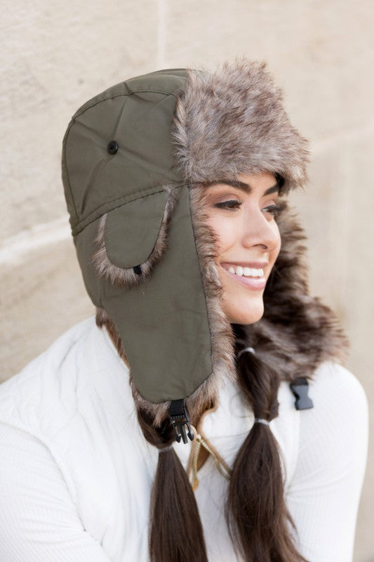 Olive faux fur winter hat with quilted lining and ear flap, side view
