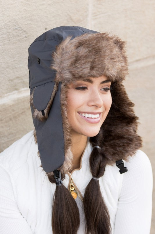 Gray faux fur ear flap hat with snap detail, side view
