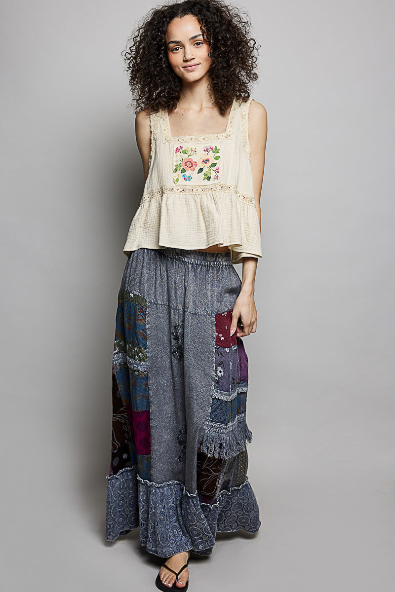 Charcoal patchwork maxi skirt with tonal embroidery, textured ruffle trim, and elastic waistband.