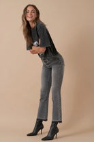 Model wearing high-rise grey bootcut jeans and black ankle boots – side view