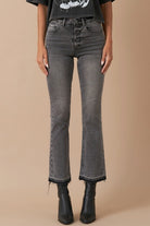 Close-up of grey denim with button fly and released hem detail