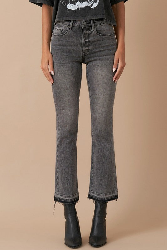Close-up of grey denim with button fly and released hem detail