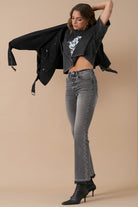 Model wearing high-rise grey bootcut jeans and black ankle boots – side view