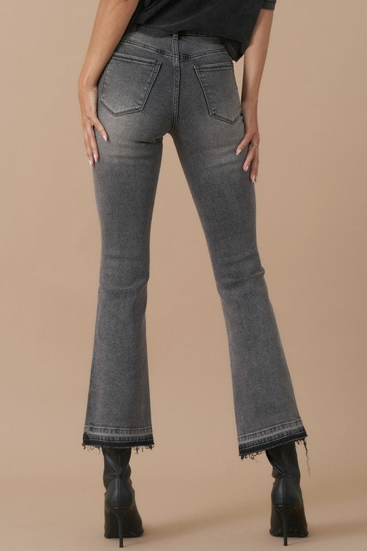 Close-up of grey denim with button fly and released hem detail-back view