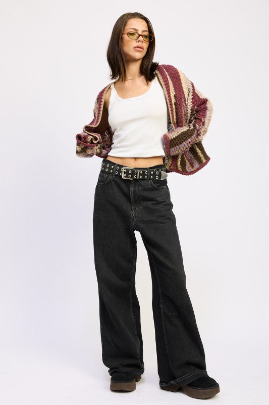 Full-length shot of burgundy striped cardigan styled with black denim and belt – modern street look

