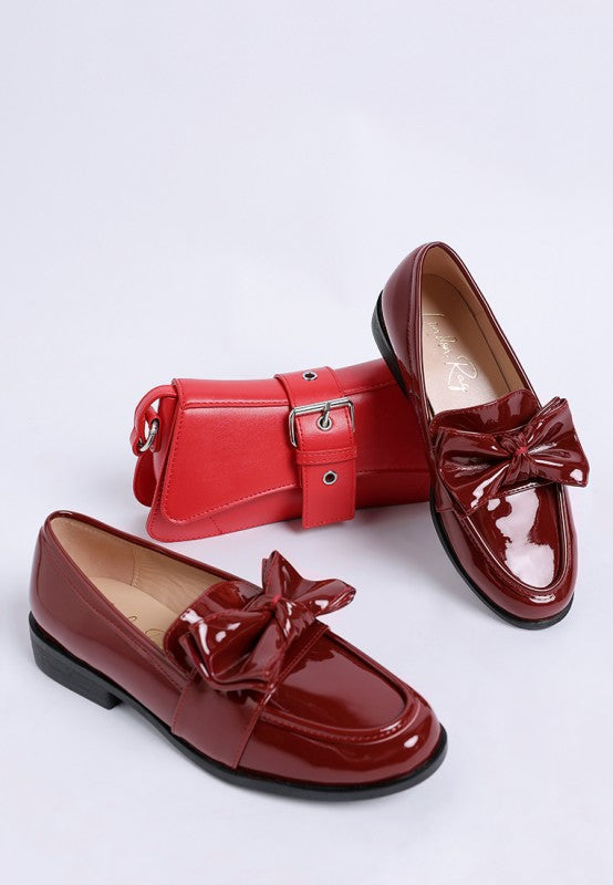 wine red patent loafers with matching red bow and bag
