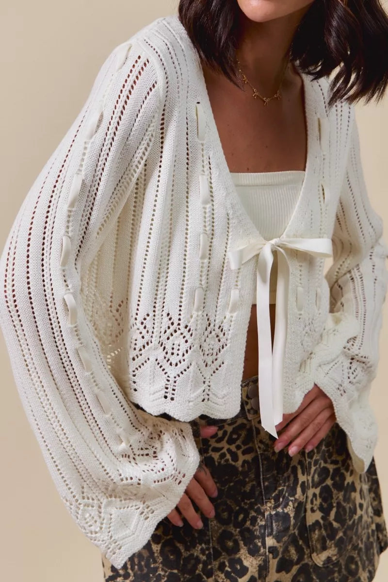Close up of off white tie front knit cardigan with textured pointelle pattern
