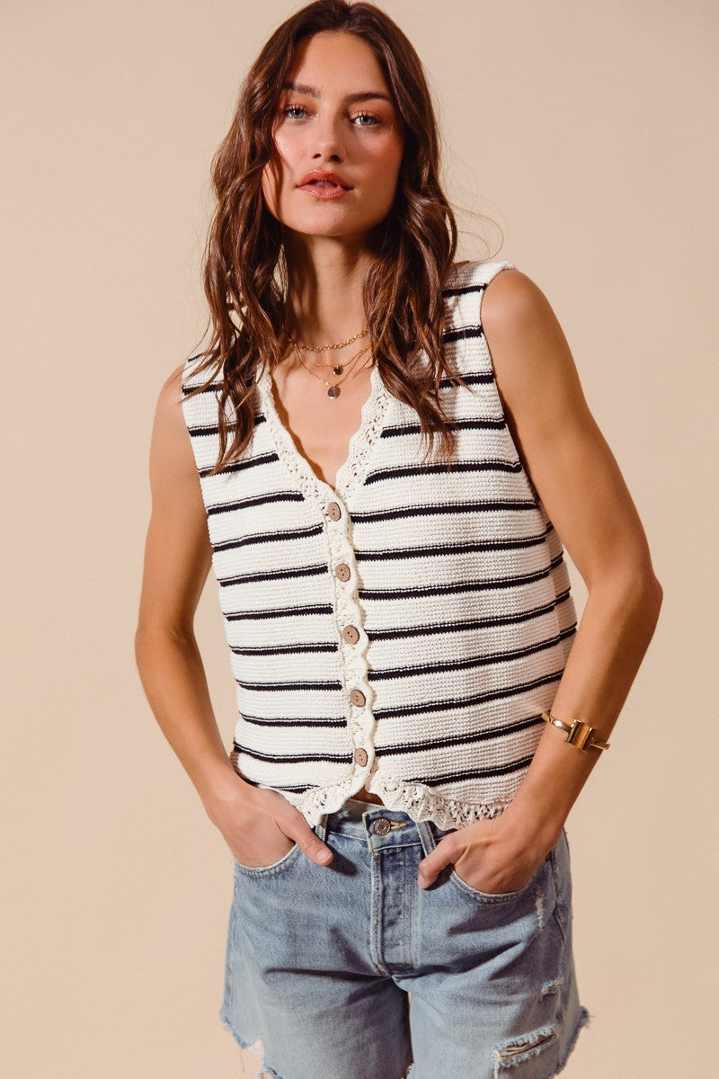 Woman wearing cream and black striped knit vest with crochet trim
