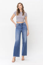 Front view of model wearing medium wash high-waisted wide-leg jeans with frayed hem-AVAH