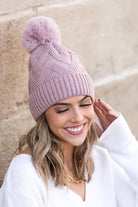Mauve knit winter hat with faux fur pom, front view

