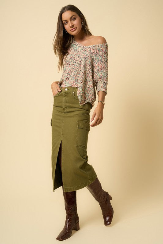 Side angle of olive cargo midi skirt featuring front slit detail.
