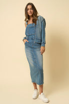 Denim overall dress styled with matching denim jacket – casual look