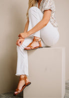 AVAH-Model wearing tan flat sandals with bold buckle detail
