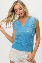 Woman wearing sky blue pearl embellished sweater vest with V neckline front view
