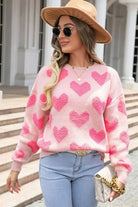 Textured heart sweater in blush pink styled with wide-brim hat and sunglasses
