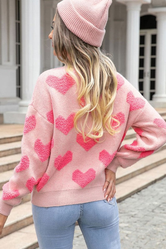 Back view of pink heart textured knit sweater showing full heart pattern