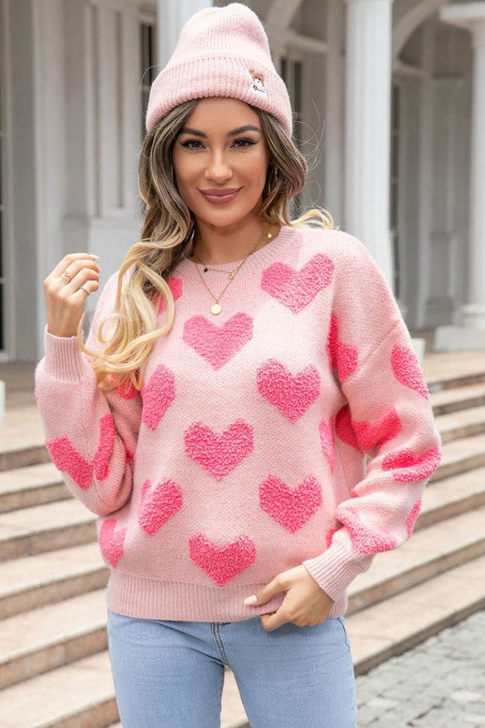 Blush pink heart textured knit sweater front view styled with light wash jeans
