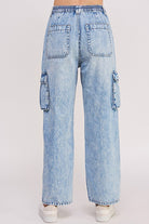 Back view of light blue denim cargo pants on a white background