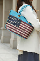 Woman carrying turquoise tote bag with American flag print and gold hardware