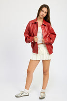 Oversized red faux leather jacket styled casually with sneakers, full outfit view