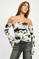 Off-shoulder black and ivory floral mesh top styled with dark cuffed jeans