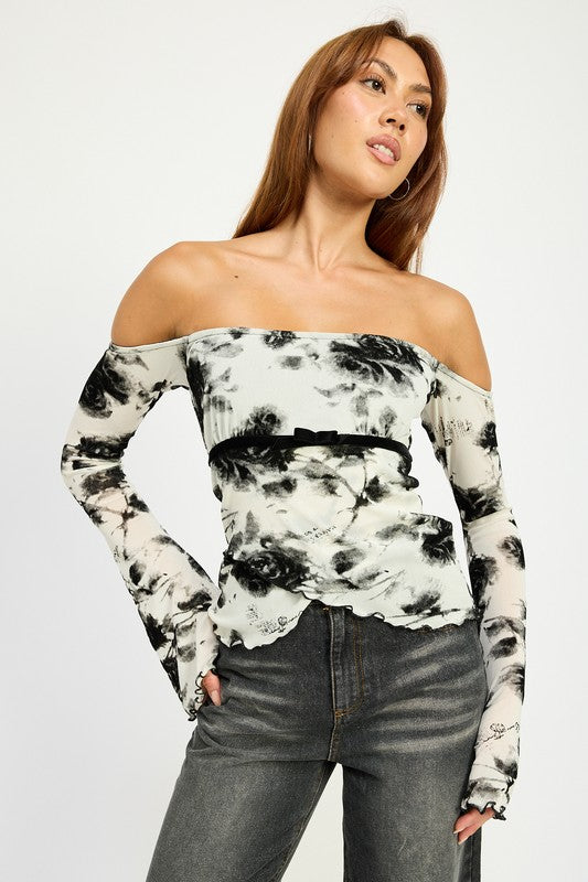 Off-shoulder black and ivory floral mesh top styled with dark cuffed jeans