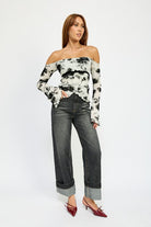 Full body look of floral off-shoulder top paired with dark denim jeans
