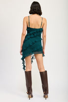 Back view of emerald green mini dress with V-neckline and asymmetrical hem