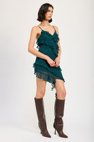 Side profile showing adjustable spaghetti straps and cascading ruffles in emerald green
