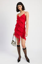 Model styling red ruffle mini dress with sheer black socks and pointed heels