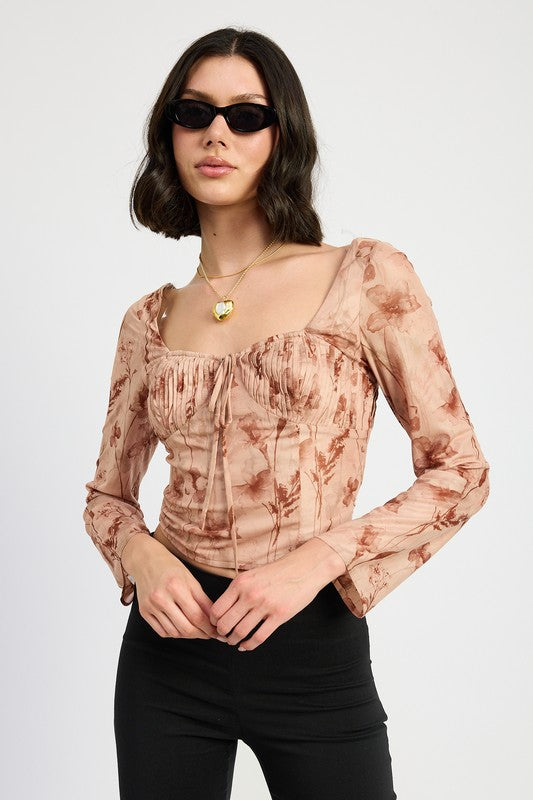 Model wearing a floral long sleeve top and sunglasses on a plain background-AVAH