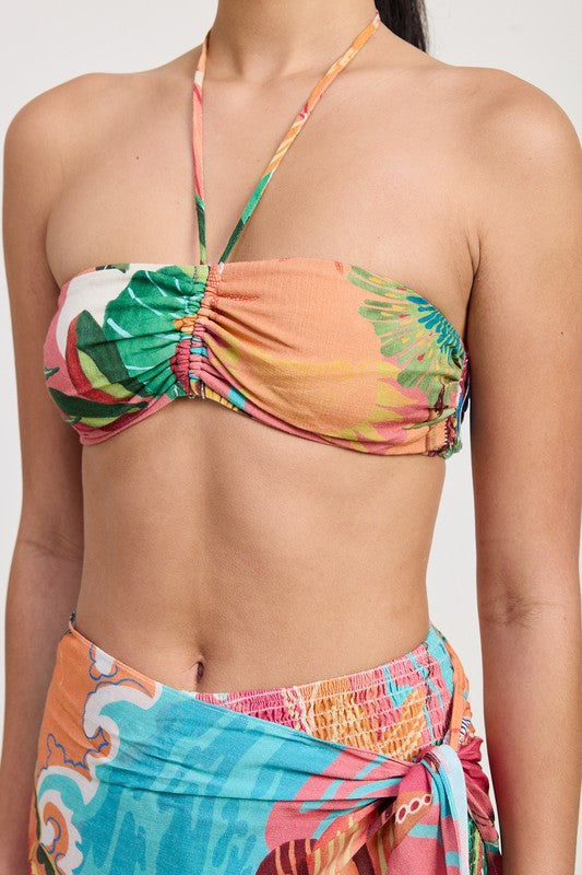 Close-up of ruched bandeau top with green, peach, and coral detailing
