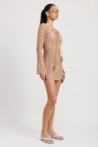 Side profile of tan crochet cover-up showing sleeve and hem length