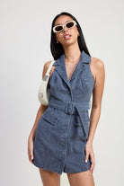 Model wearing slate belted denim mini dress with white sunglasses and cream shoulder bag-AVAH