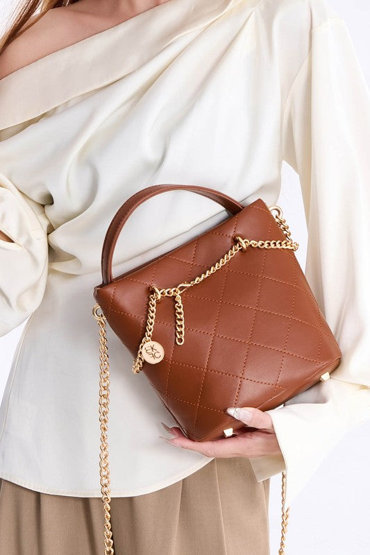 Side view of brown quilted mini tote with gold charm
