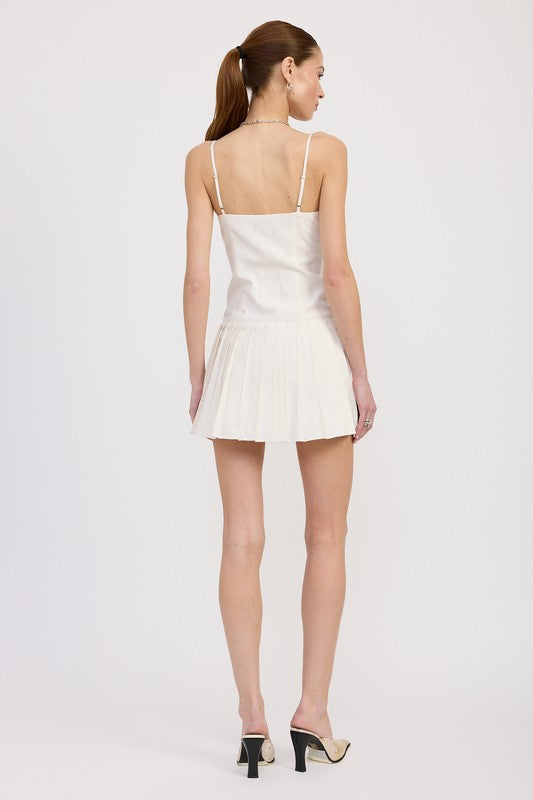Back view of ivory pleated mini dress showing square back and adjustable straps
