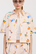 Close-up of the cropped cotton button-up shirt featuring chest pocket and artistic summer print.