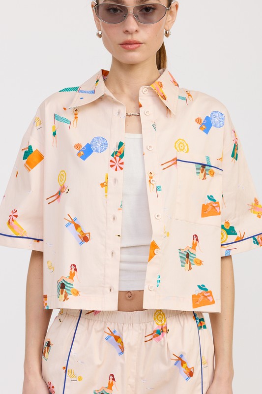 Close-up of the cropped cotton button-up shirt featuring chest pocket and artistic summer print.