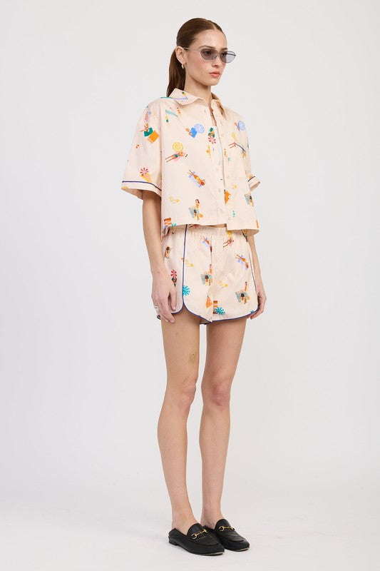 Side angle of model in matching print cotton co-ord set with playful pattern and relaxed fit.